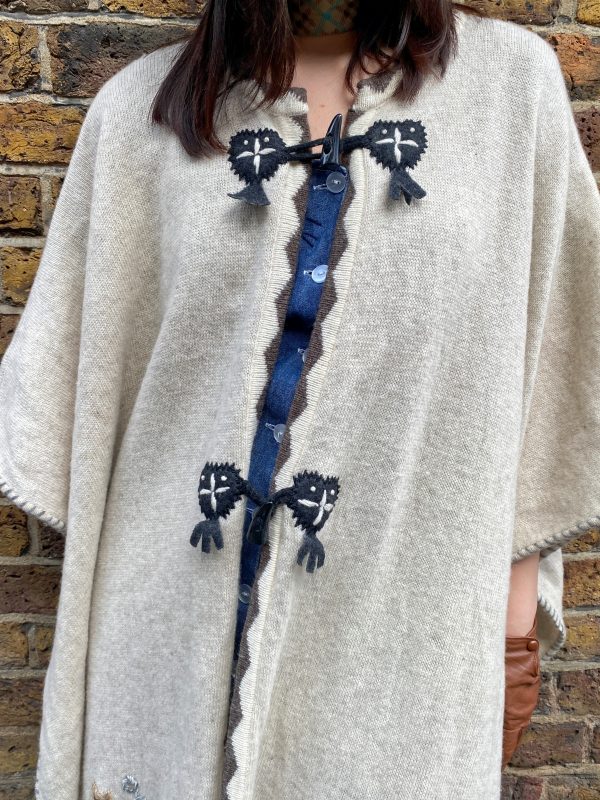 Front button and tie closure of late 1990s embroidered poncho with folk-style embellishment