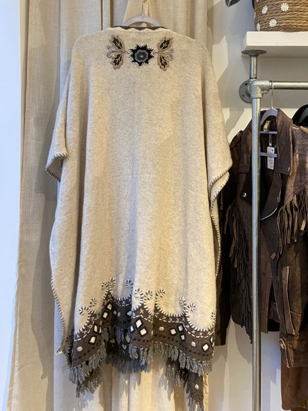 Back embroidery detail of late 1990s embroidered poncho featuring folk-inspired floral and leaf motifs