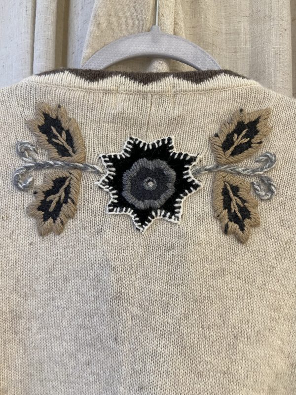 Back embroidery detail of late 1990s embroidered poncho featuring folk-inspired floral and leaf motifs
