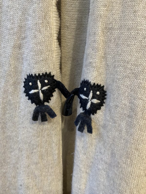 Front button and tie closure of late 1990s embroidered poncho with folk-style embellishment
