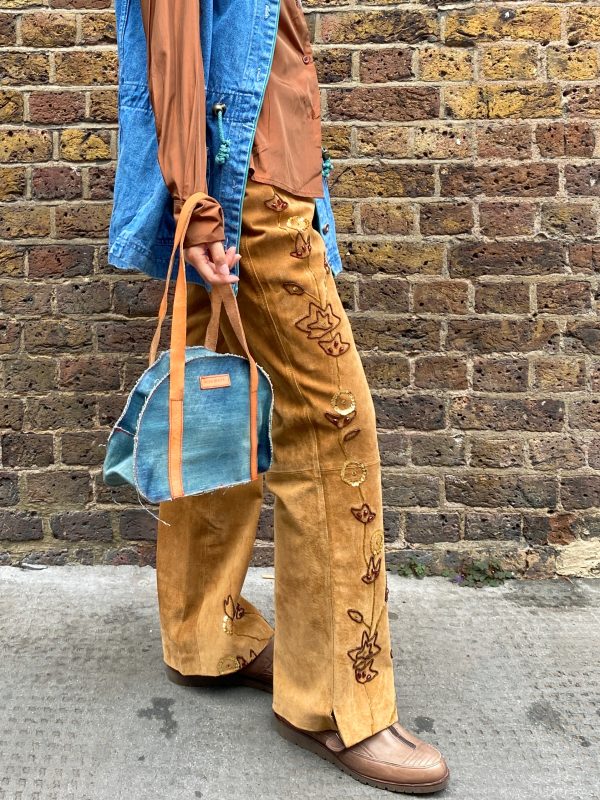 model wearing 1990s embroidered suede trousers with sequin florals and relaxed fit