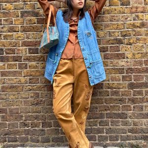 Model wearing oversized 1970s Alpine embroidered denim waistcoat, styled with casual layering