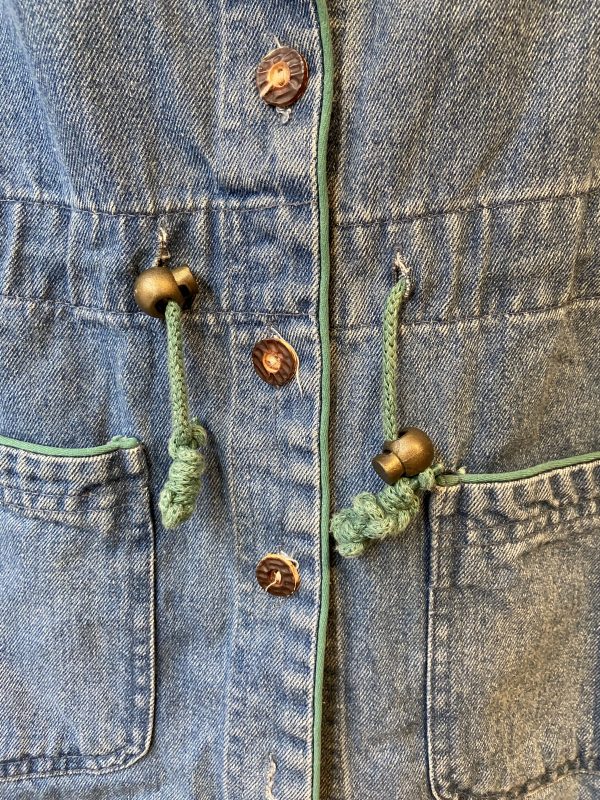 Adjustable drawstring waist on vintage 1970s embroidered denim vest