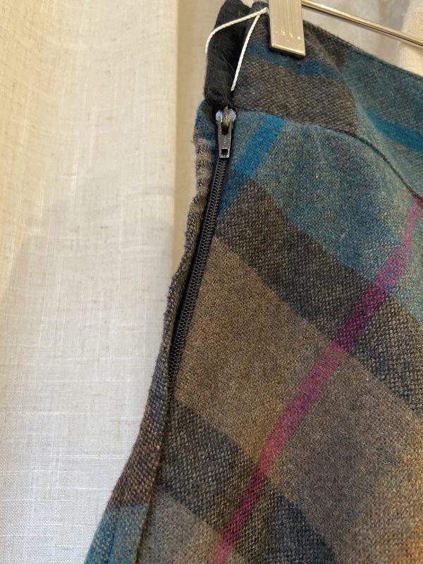 Vintage zip detail on 1960s plaid A-line skirt, showing plastic zipper and clean stitching.