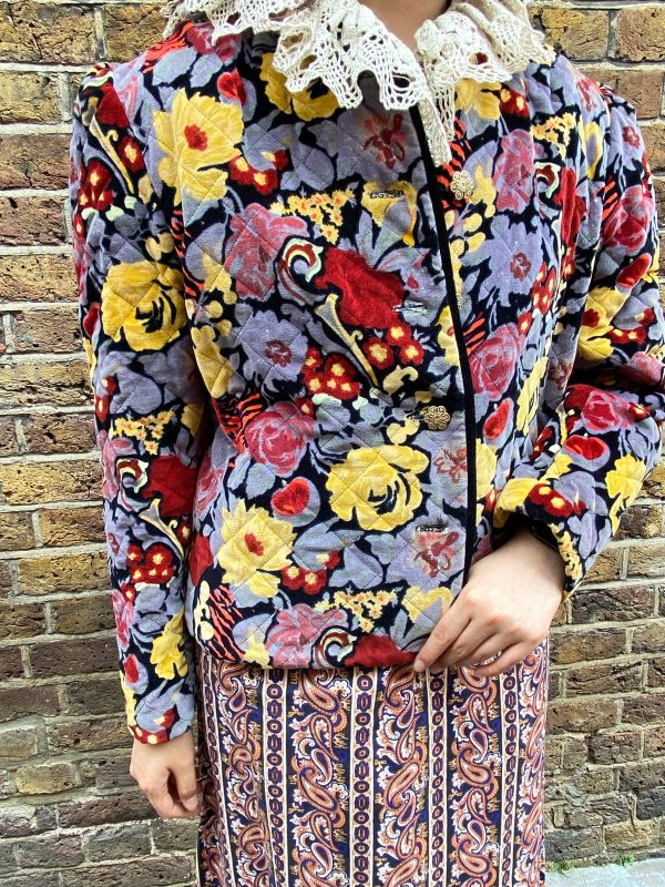 Front view of 1980s quilted floral jacket with bold red and yellow print