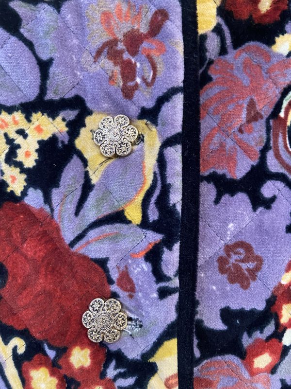 Close-up of metal flower buttons on 1980s quilted floral jacket