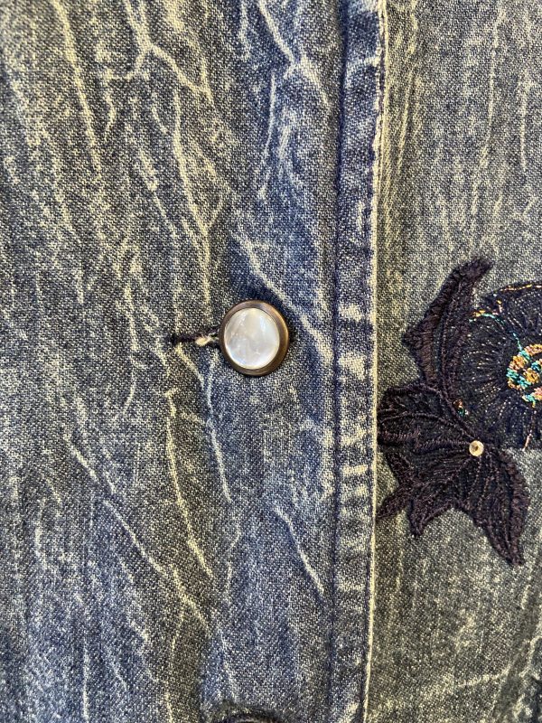 Close-up of floral embroidery on vintage Marciano denim jacket