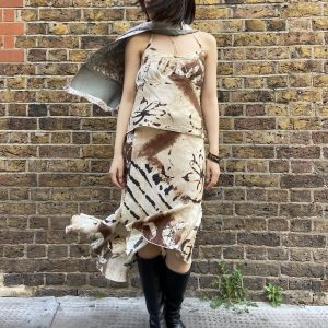Model wearing early 2000s abstract linen two-piece set in front of brick wall
