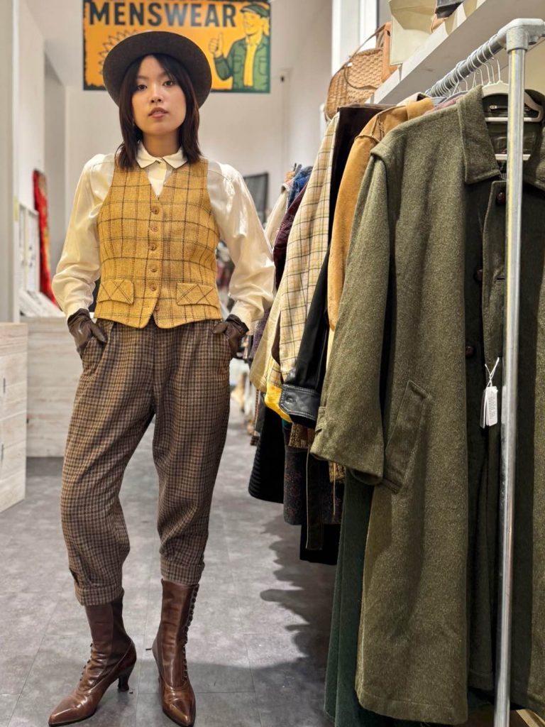 Model wearing Stuart Weitzman for Capricio Victorian-revival boots from the 100-year-old ambassador wardrobe, styled with checked jodhpurs and waistcoat in a vintage shop
